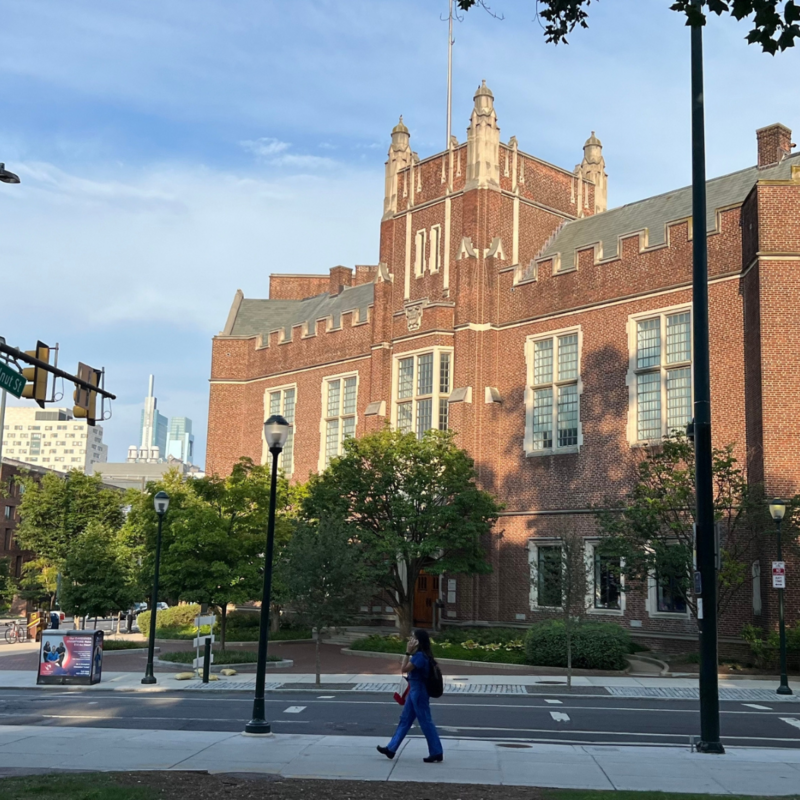 Student walking as the sunsets in front of Fisher Bennett Hall