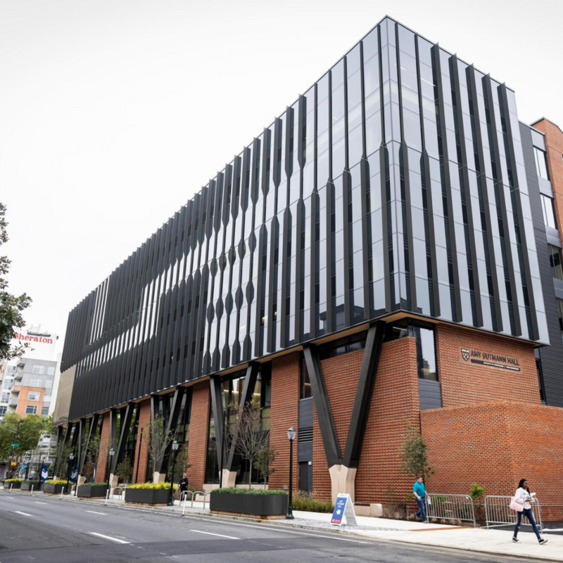 Exterior of Amy Gutmann Hall with people walking by in front of it.