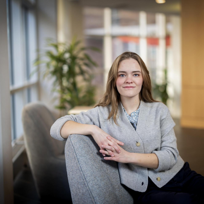 Fourth-year Charlotte Brown posing for a photo while sitting in a chair