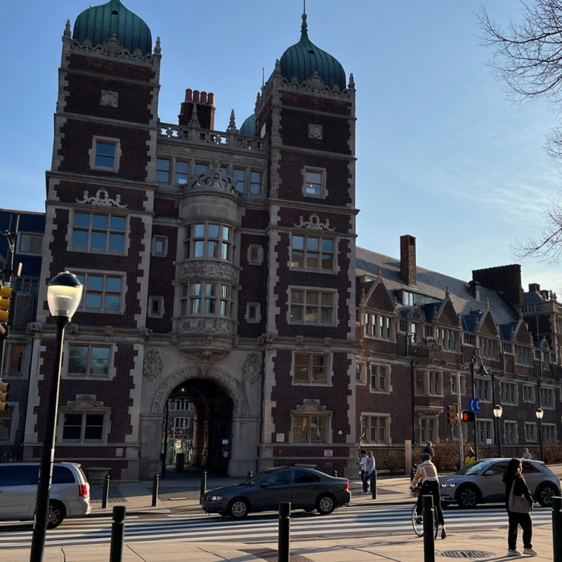 People waiting to cross the street in front of the Penn Quad entrance